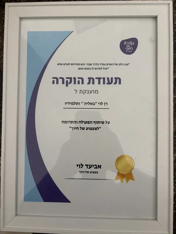 תעודת הוקרה ממוסגרת מעמותת צעצוע של חיוך. כתוב בה: "טוב הלב של האדם נמדד בדרך שבה הוא מתייחס לאדם שלא יכול לתרום לו בשום אופן". תעודת הוקרה מוענקת לרן לוי "באליה" ותלמידיו, על שיתוף הפעולה והתרומה ל"צעצוע של חיוך". חתום: אביעד לוי, צעצוע של חיוך.